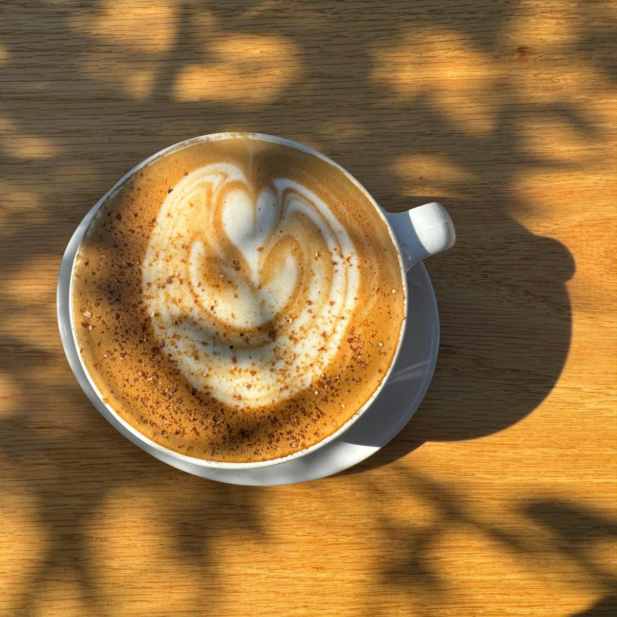 A cup of coffee with latte art on a wooden table